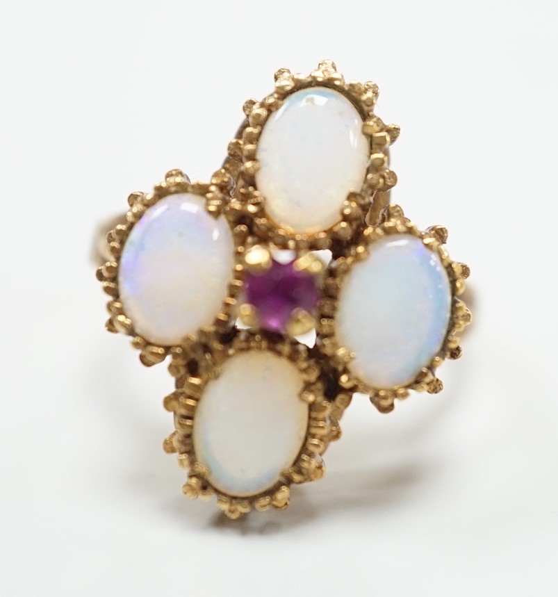 A 1970's 9ct gold, four stone white opal and single stone ruby cluster set dress ring, size O, gross weight 5.2 grams.
